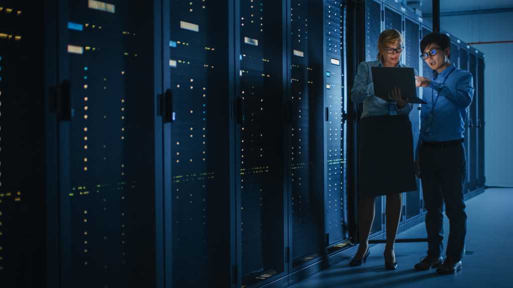 Shot of Dark Data Center With Multiple Rows of Fully Operational Server Racks. Modern Telecommunications, Cloud Computing, Artificial Intelligence, Database, Supercomputer. Pink Neon Light.